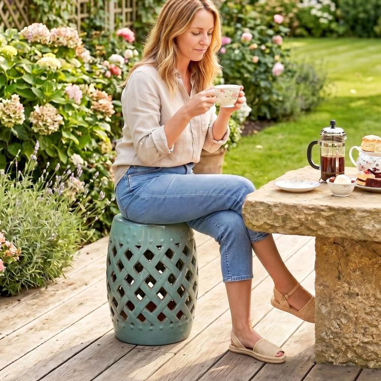 Teal ceramic garden stool with glazed lattice cutouts and rounded top