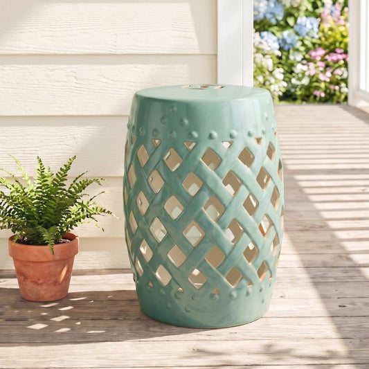 Green ceramic garden stool on wooden patio with lattice cutout sides