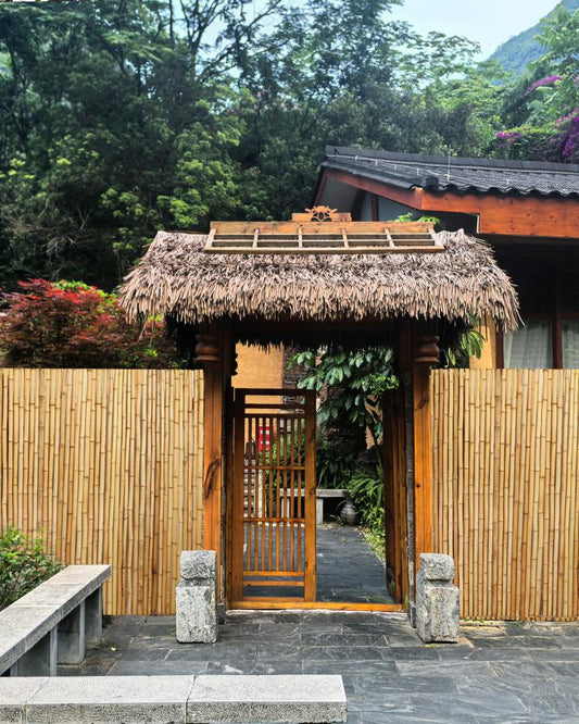 Natural bamboo fence panel with thatched roof gate and vertical bamboo poles