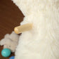 White plush alpaca rocking horse with wooden rocker arm detail