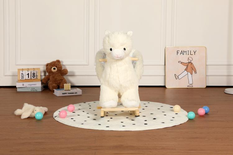 White plush alpaca rocker toy with wooden base and black-dot play mat