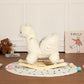 White plush alpaca rocking toy with arched neck and wooden rocker base