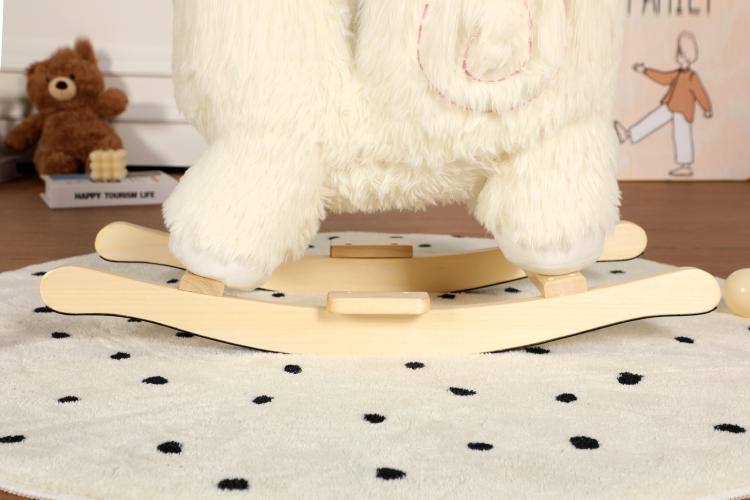 Close-up of white plush alpaca ride-on toy feet on wooden rocking base