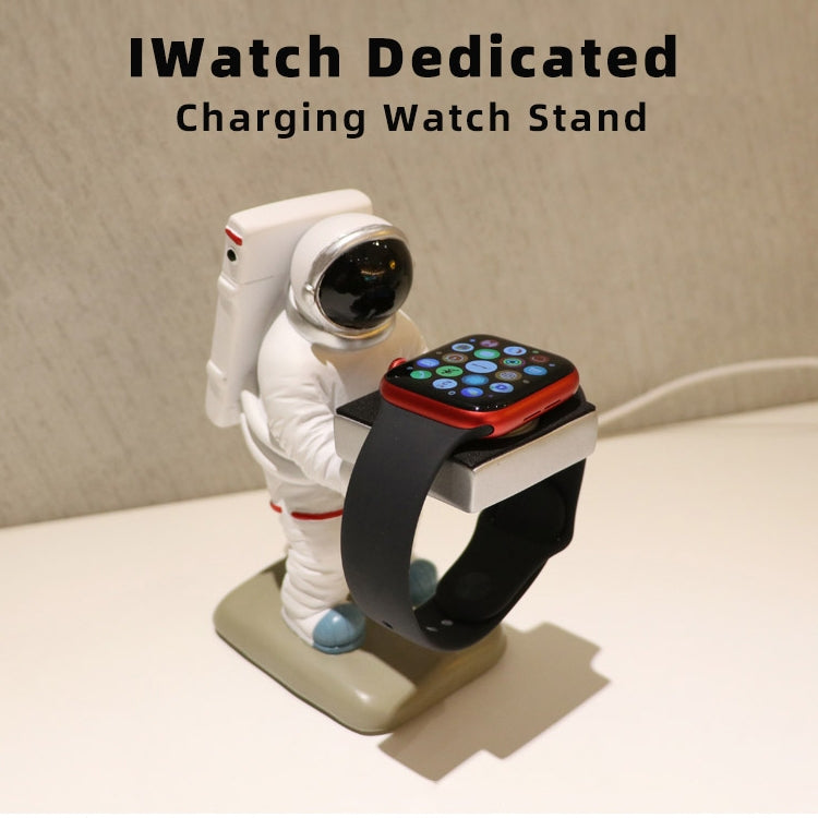 Astronaut watch stand holding an Apple Watch on a black charging cradle