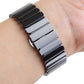 Two-tone black and silver ceramic Apple Watch band worn on wrist