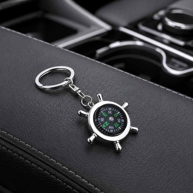 Silver compass-style keychain with round dial and swivel ring, green markings