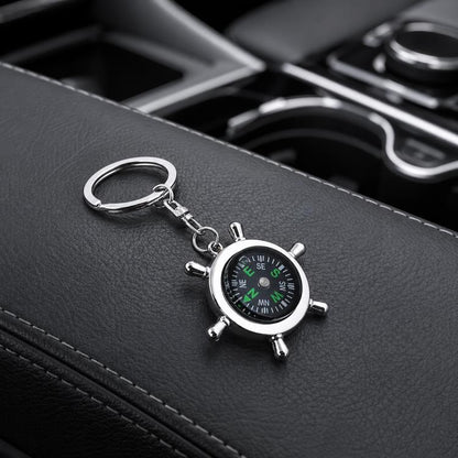 Silver compass-style keychain with round dial and swivel ring, green markings