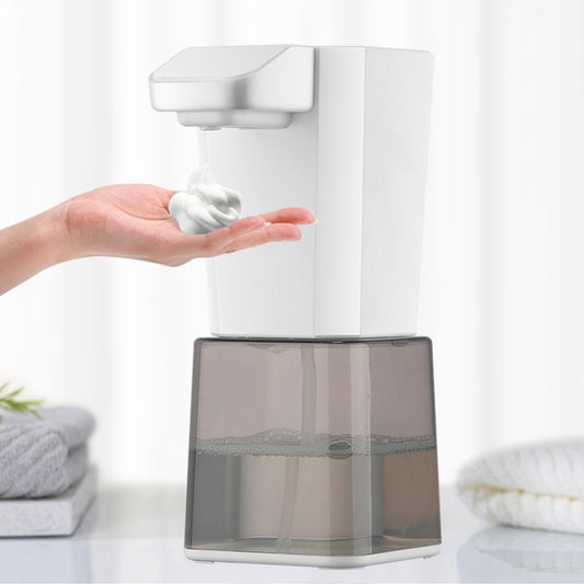 Automatic foam soap dispenser with white body and translucent container, foam dispensing from nozzle