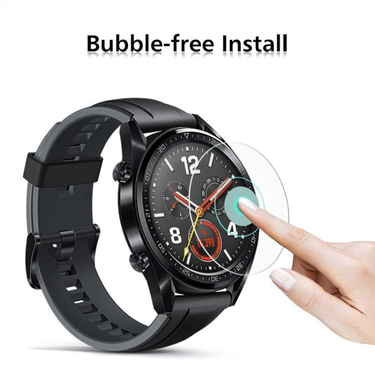 Bubble-free tempered glass film being applied to a black watch with a finger