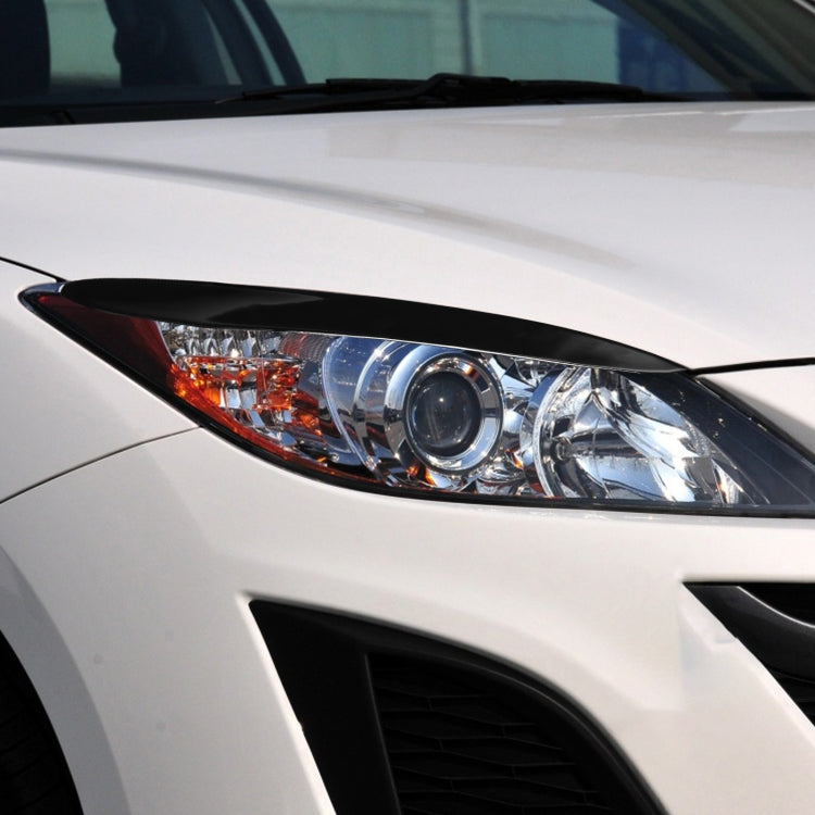 Black headlight eyebrow trim installed above the car headlamp