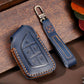 Navy blue leather key protective case with brown stitching and embossed button layout