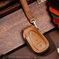 Tan/brown leather key fob cover close-up with stitched edge and key ring loop
