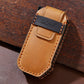Tan leather key fob cover with metal key ring, embossed logo, and orange border stitching