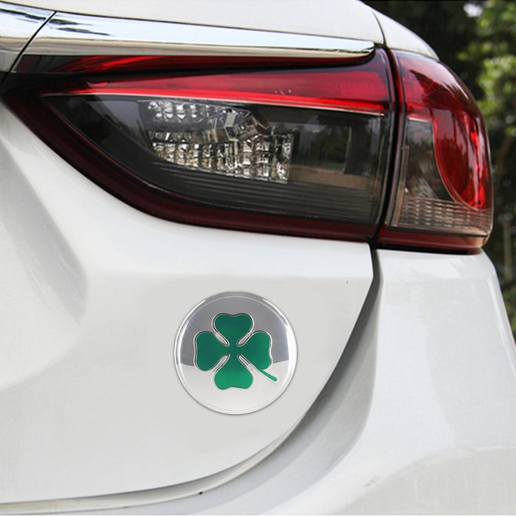 Round car wheel hub decorative sticker with green four-leaf clover on silver