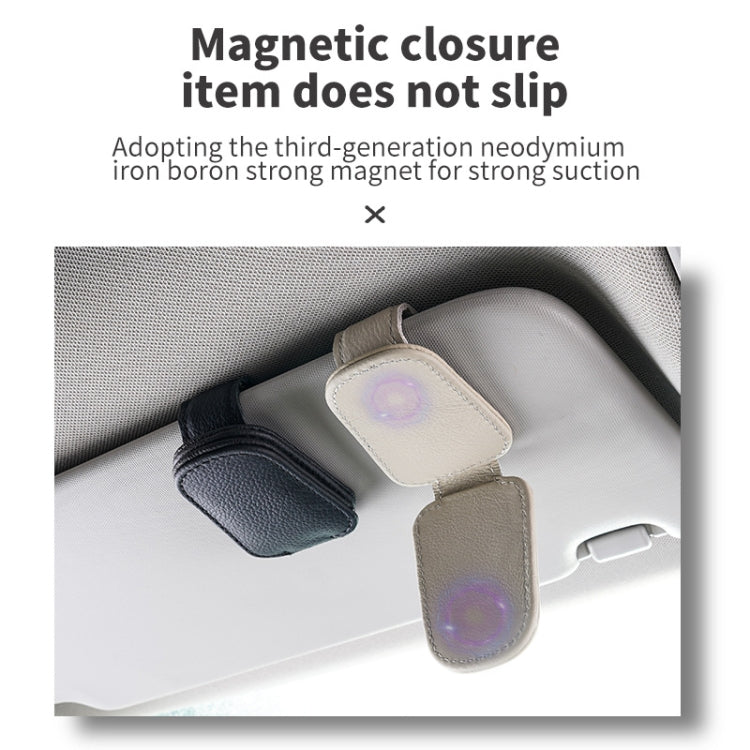 Beige and black sun visor clip holders storing glasses
