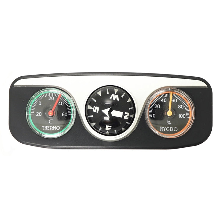 Car dashboard compass device with thermometer, compass direction ball, and hygrometer dials.