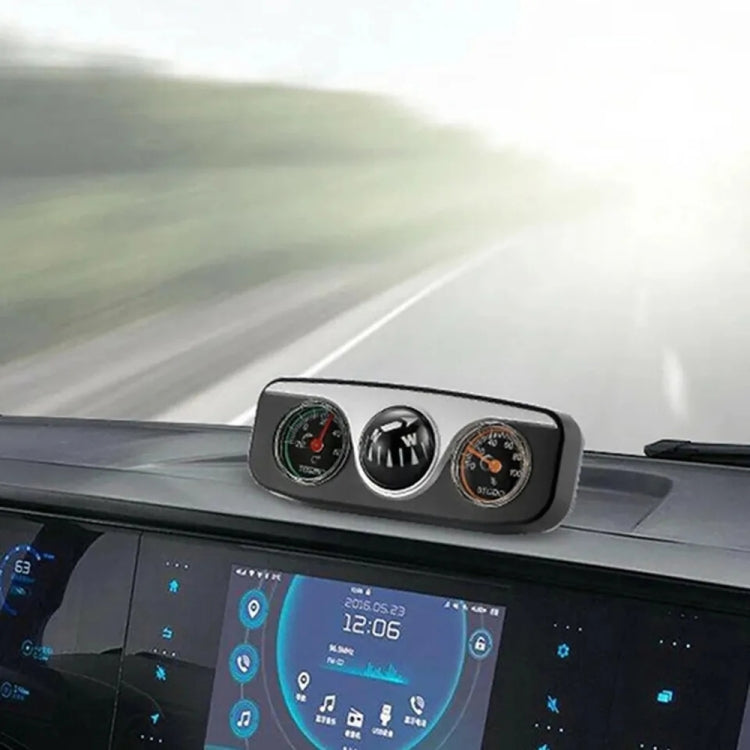 Installed three-gauge car dashboard compass with direction ball, thermometer, and hygrometer.