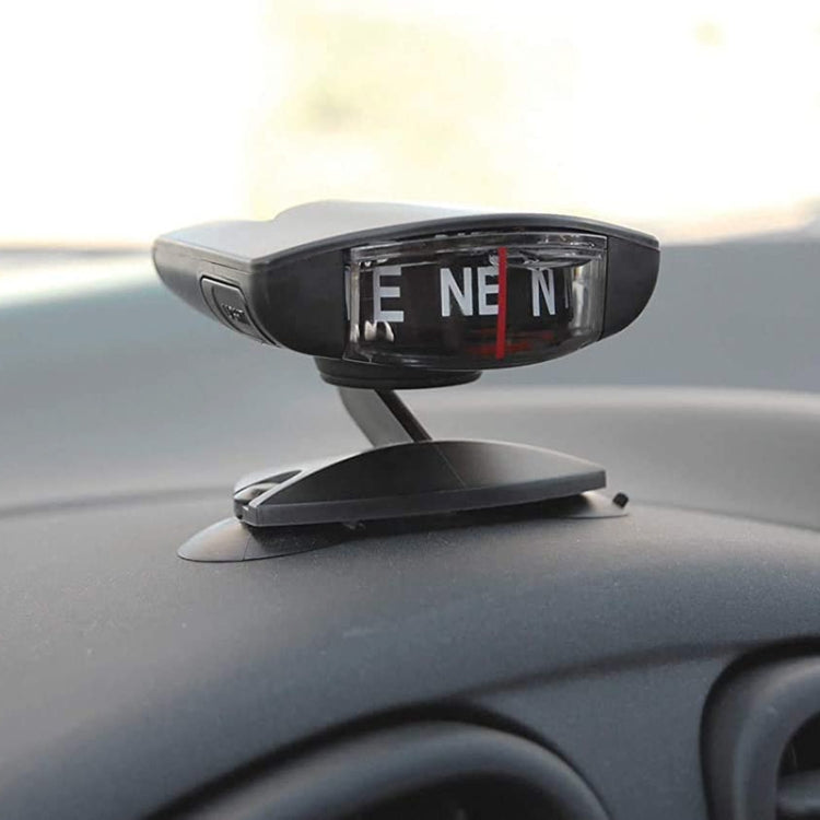 Black LC35 compass ornament mounted on car dashboard with suction cups