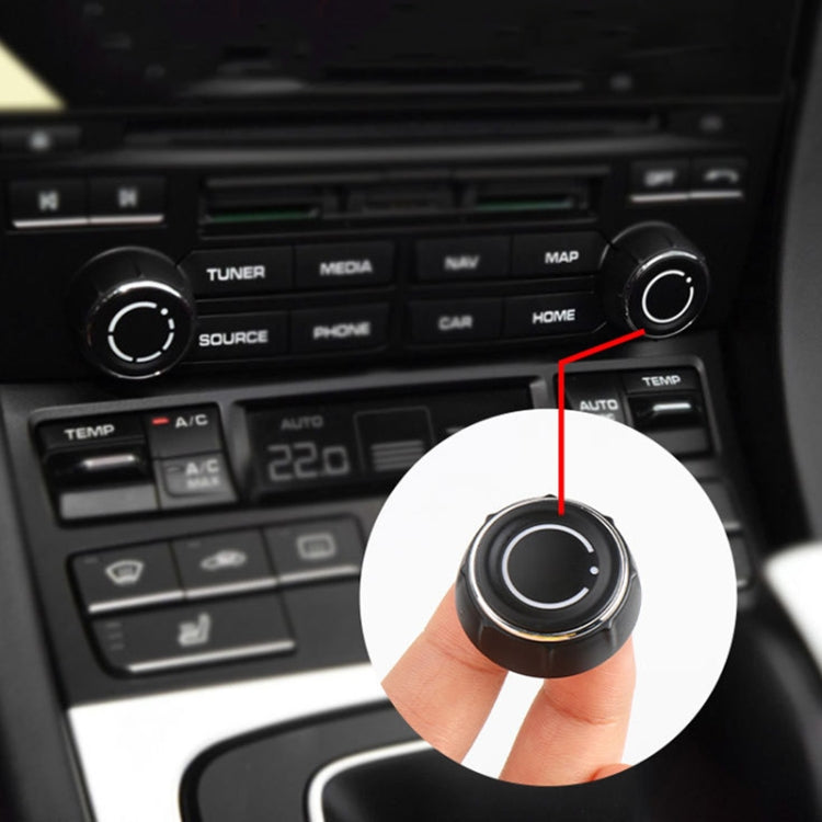 Black audio volume knob cover with silver trim ring held in hand
