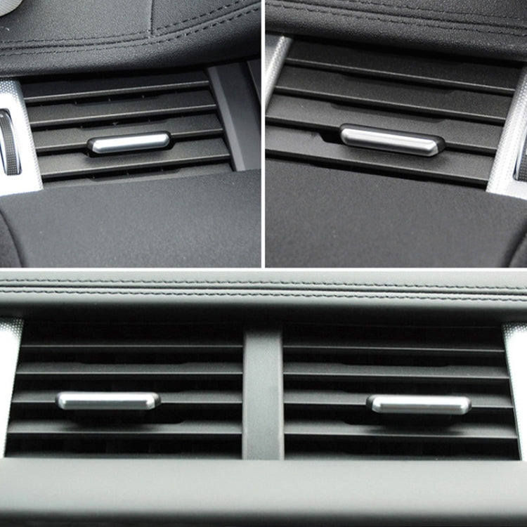 Silver air vent adjustment strip centered on dashboard vent grille.