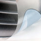 Close-up of self-adhesive faux vent decal with protective backing and curved edge