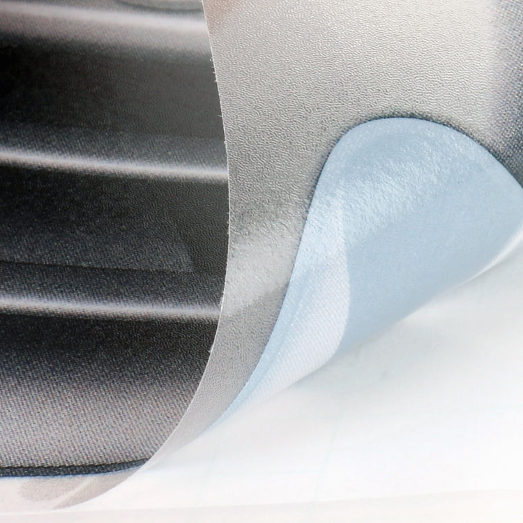 Close-up of self-adhesive faux vent decal with protective backing and curved edge