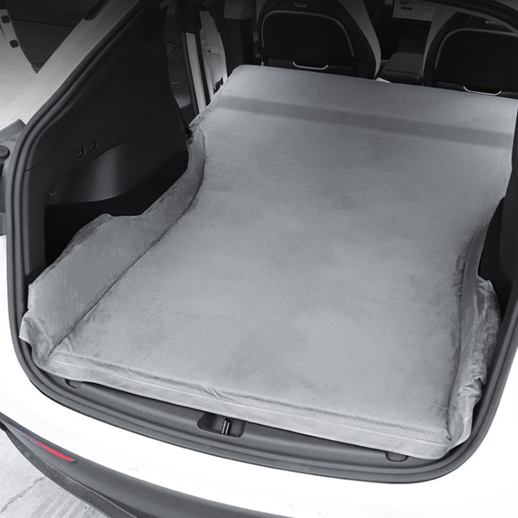 Gray suede non-inflatable car mattress laid flat in trunk