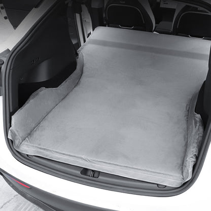 Gray suede non-inflatable car mattress laid flat in trunk