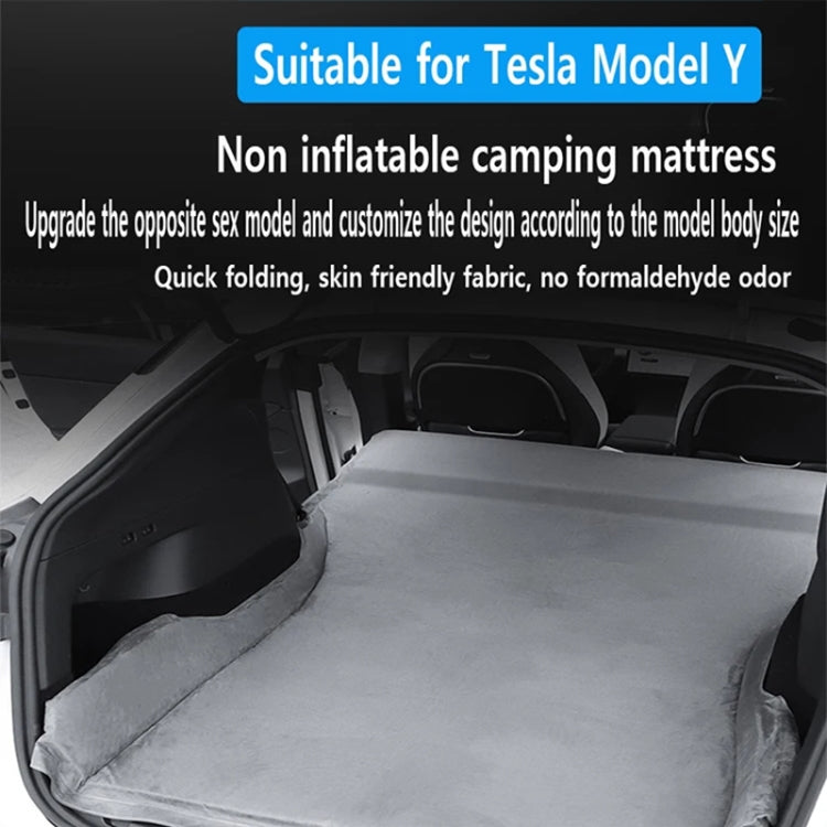 Gray suede non-inflatable camping mattress laid flat in car trunk