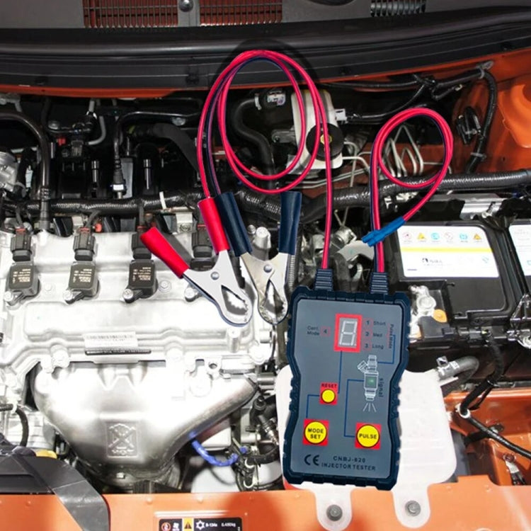 Automobile injector tester connected in car engine bay with red and black leads
