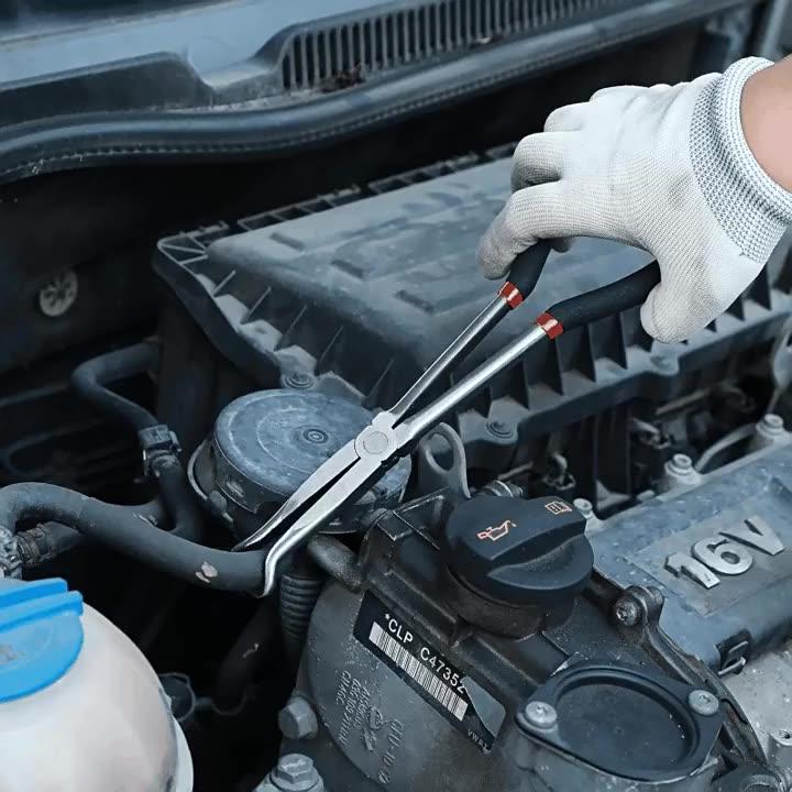 Gloved hand using extended reach hose grip pliers on an engine hose connection