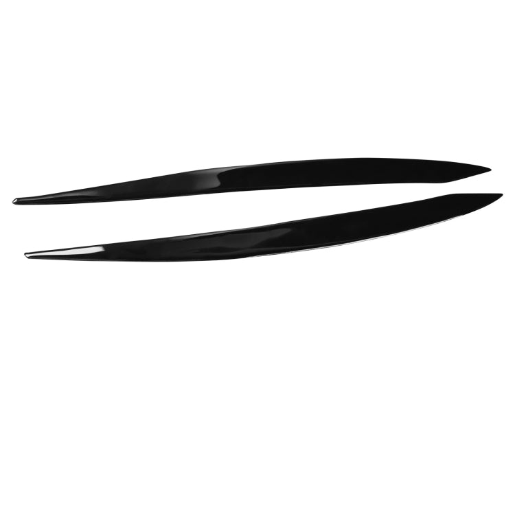 Pair of black curved headlight eyebrow stickers, slim decal strips shown on white.