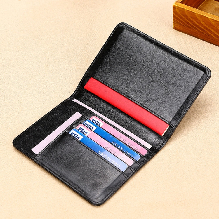 Black RFID leather passport holder with card slots and red elastic band inside.