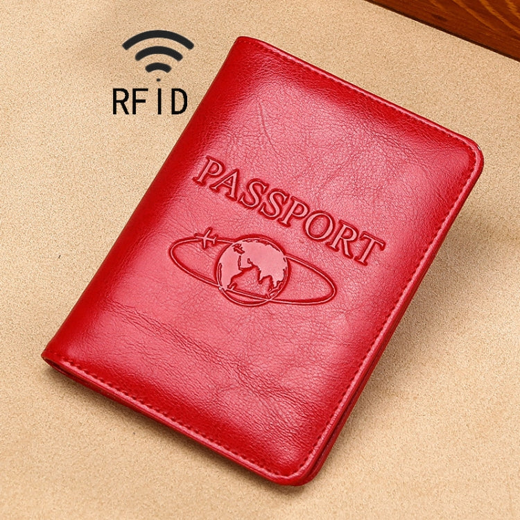 Red RFID leather passport holder with embossed PASSPORT and globe emblem.