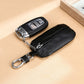 Black litchi-texture key pouch with zipper, metal clasp, and attached keyring chain
