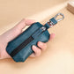 Teal litchi-texture zippered car key pouch held by hand with metal keyring