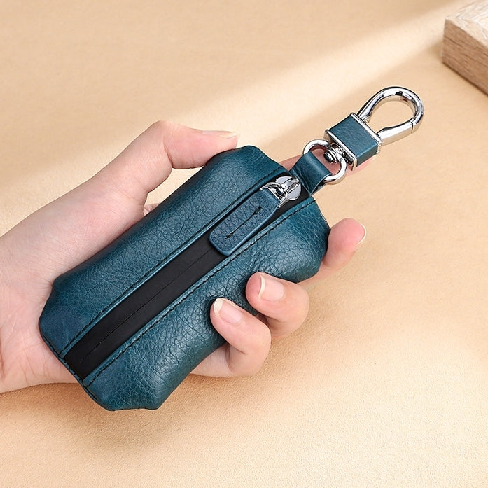Teal litchi-texture zippered car key pouch held by hand with metal keyring