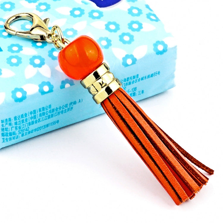 Gold-tone tassel keychain with orange bead and orange-brown leather tassel strands