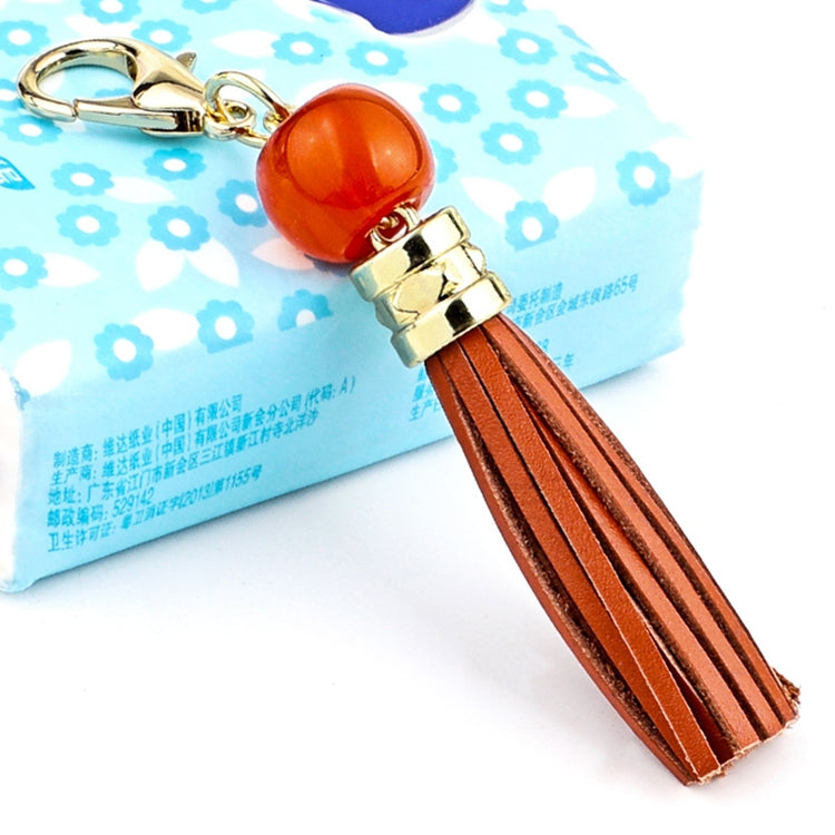 Gold-tone tassel keychain with orange bead and brown leather tassel strands