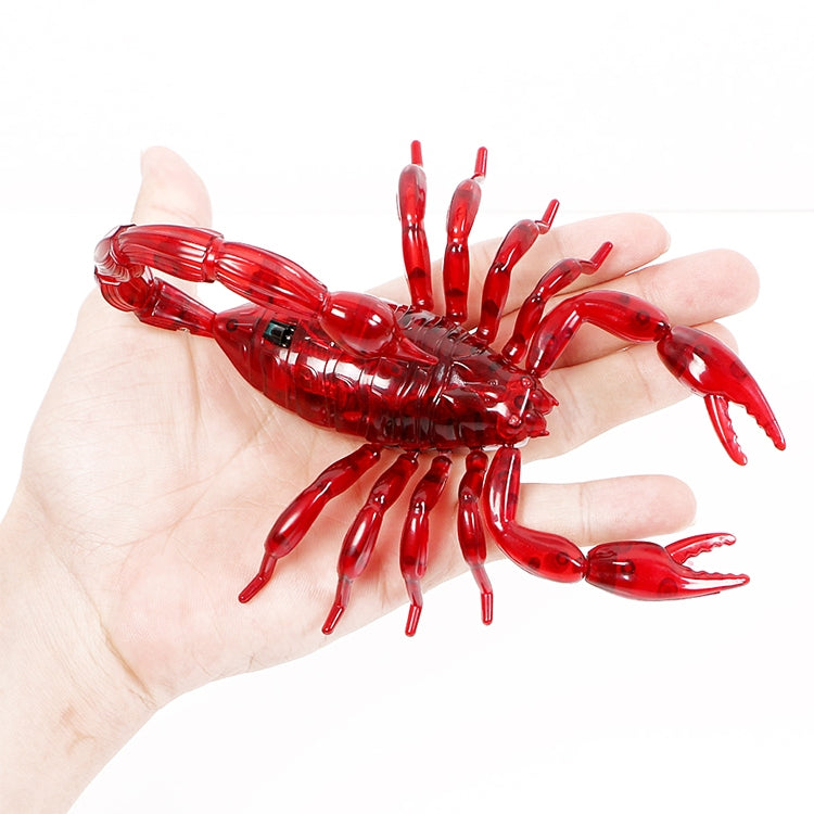 Red translucent scorpion toy held in an open palm