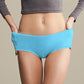 Blue women's silicone swim trunks, mid-rise briefs on model with full back coverage.