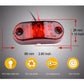Red oval LED side marker light, 66 mm x 28 mm, clear lens with two mounting holes.