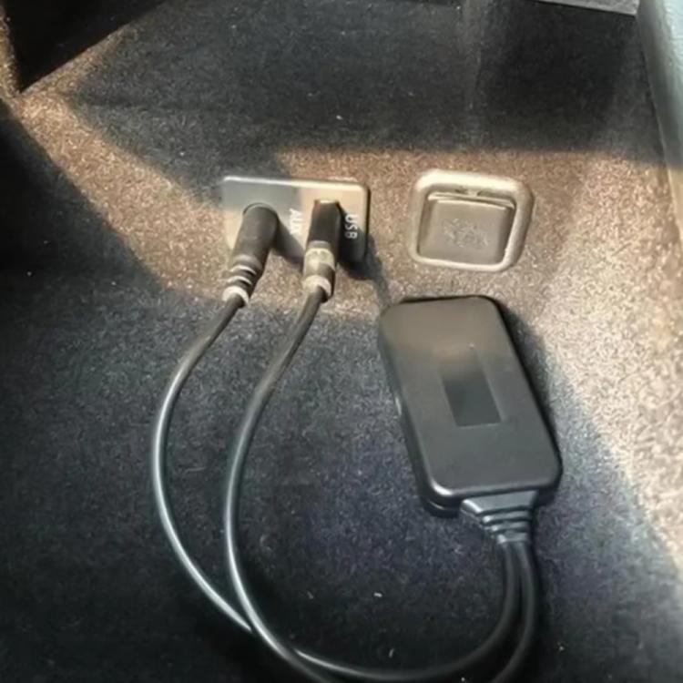 Bluetooth AUX adapter plugged into car audio port, showing USB and 3.5mm connections
