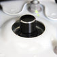 Black metal bump stop screw cap with silver trim ring and ridged top