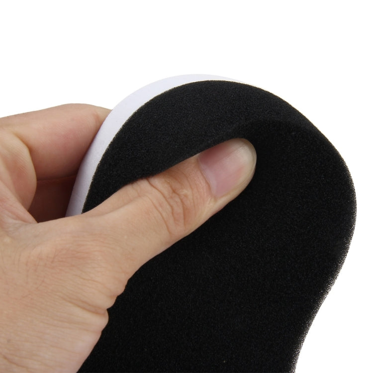 Car wax sponge held in hand, black foam with white edging, curved oval