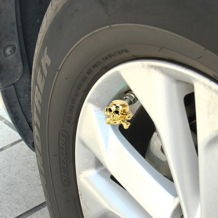 Gold skull tire valve cap cover on a vehicle wheel rim