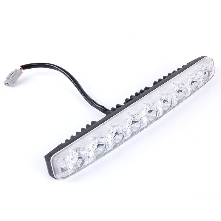 LED daytime running light bar with clear lens, black grille mount, and wiring connector