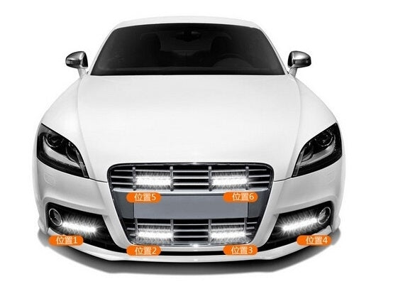 Front of a white car with integrated LED daytime running lights on
