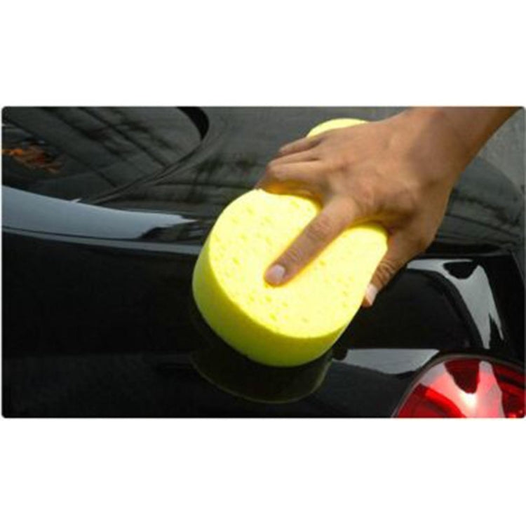 Yellow car wash sponge held by hand, porous surface for scrubbing