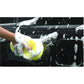 Hand scrubbing a car with a yellow porous sponge, foamy bubbles visible